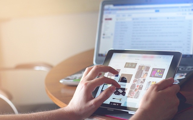 Bild mit einem Monitor und Händen, die auf dem Monitor scrollen